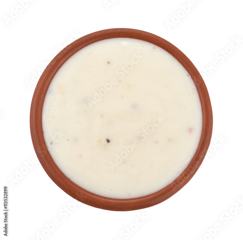Small bowl of Italian salad dressing isolated on a white background top view.