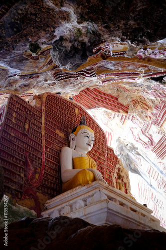 Amazing View of Buddha Statues and Religious Carvings on Limestone Rock at Kawgun Cave Temple at Hpa An, Myanmar photo