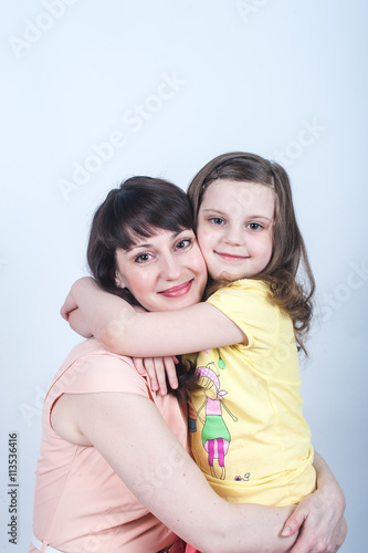 the daughter and mother together in each other's arms on a white background