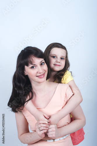 the daughter and mother together in each other's arms on a white background