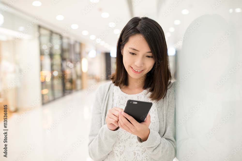 Woman use of cellphone inside shopping center Woman use of cellphone inside shopping center