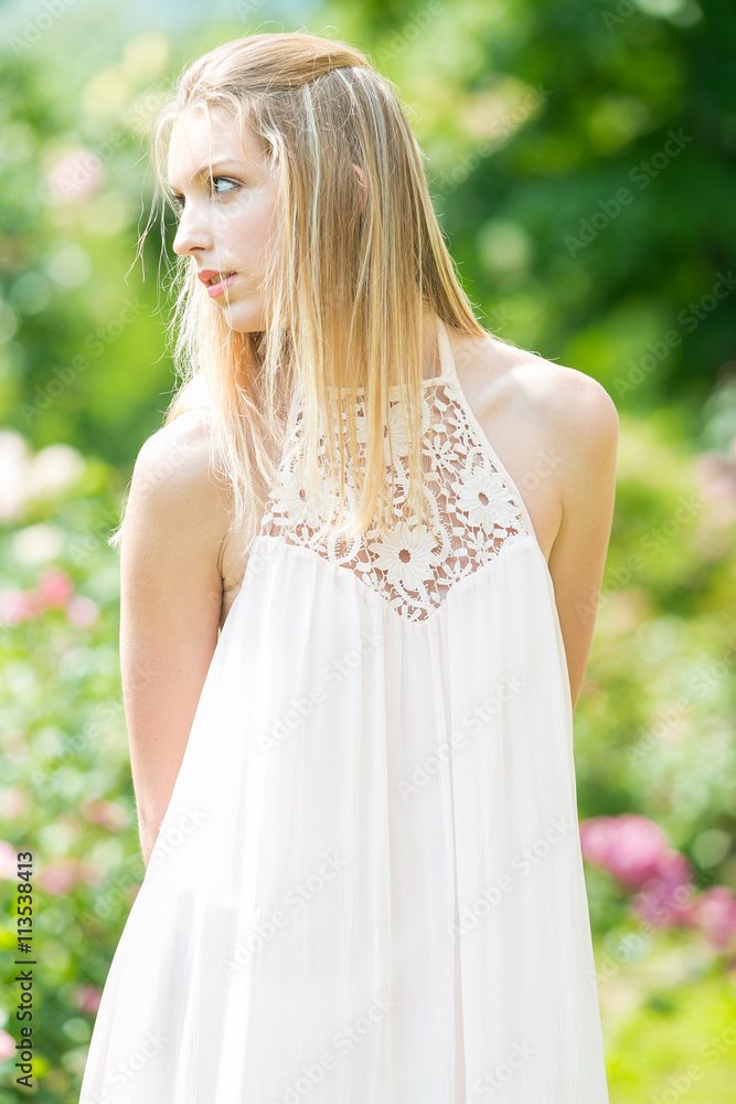 Naklejka premium Portrait of beautiful natural young woman in the rose garden