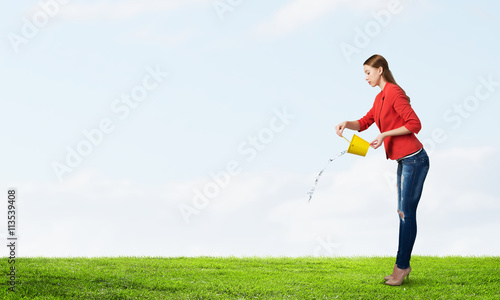Girl pouring water from bucket