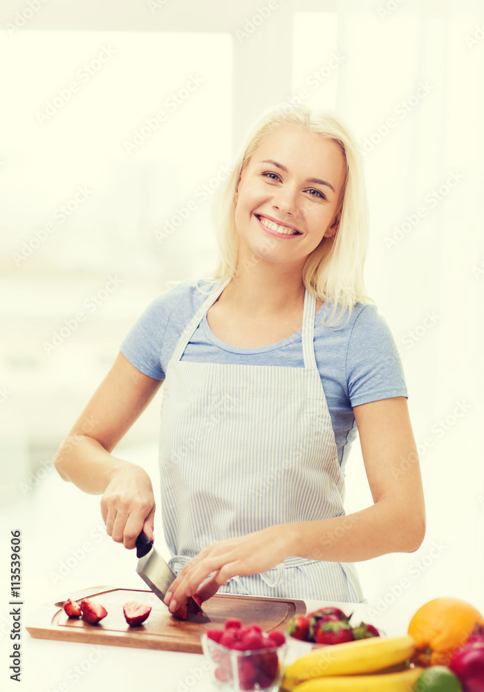 smiling young woman chopping fruits at home smiling young woman chopping fruits at home