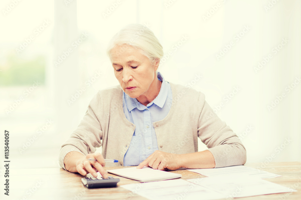 senior woman with papers and calculator at home senior woman with papers and calculator at home