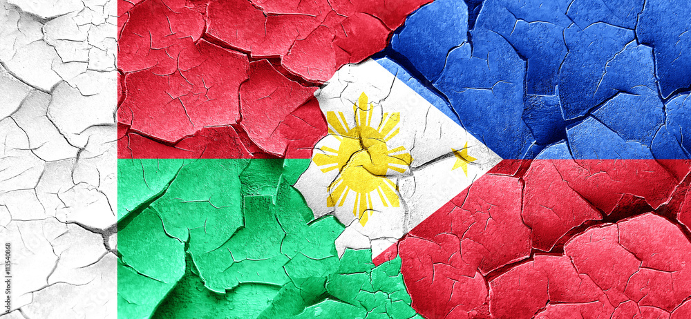 Madagascar flag with Philippines flag on a grunge cracked wall