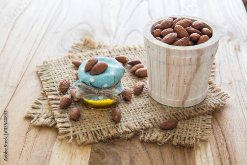 Almond oil in bottle on wooden background