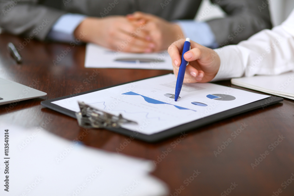 Close up of unknown business people at meeting discussing financial results Close up of unknown business people at meeting discussing financial results