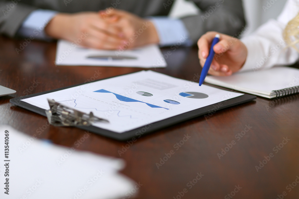 Close up of unknown business people at meeting discussing financial results Close up of unknown business people at meeting discussing financial results