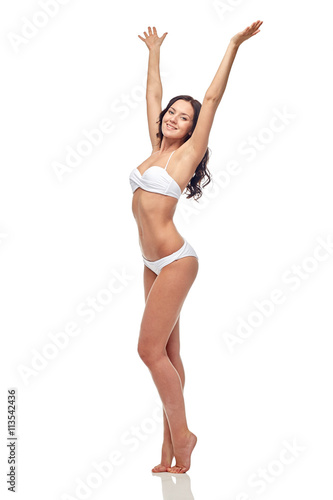 happy young woman in white bikini swimsuit dancing