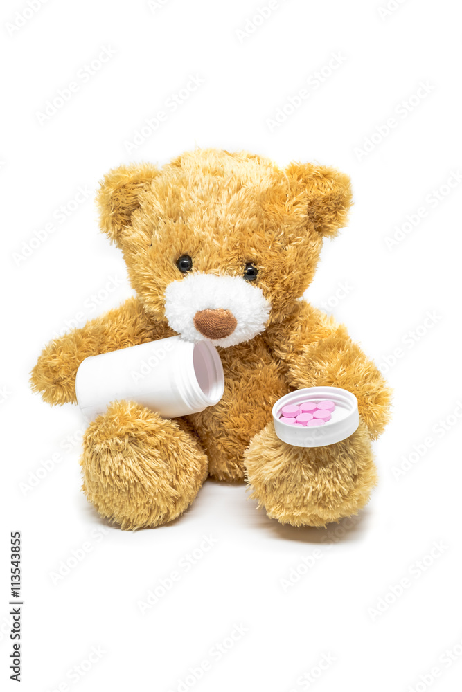 Toy teddy bear with medicine pill isolated on white background