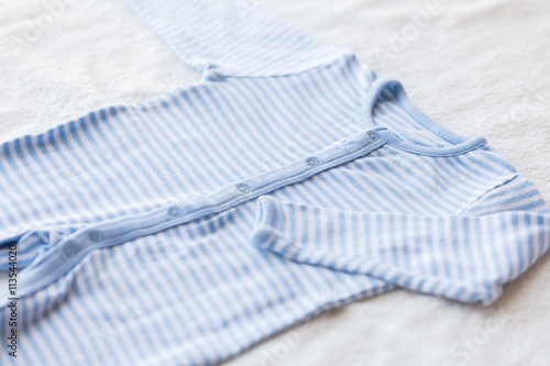 close up of baby bodysuit for newborn boy on towel