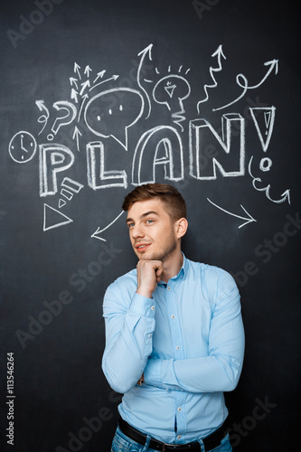 man standing over blackboard with a plan concept