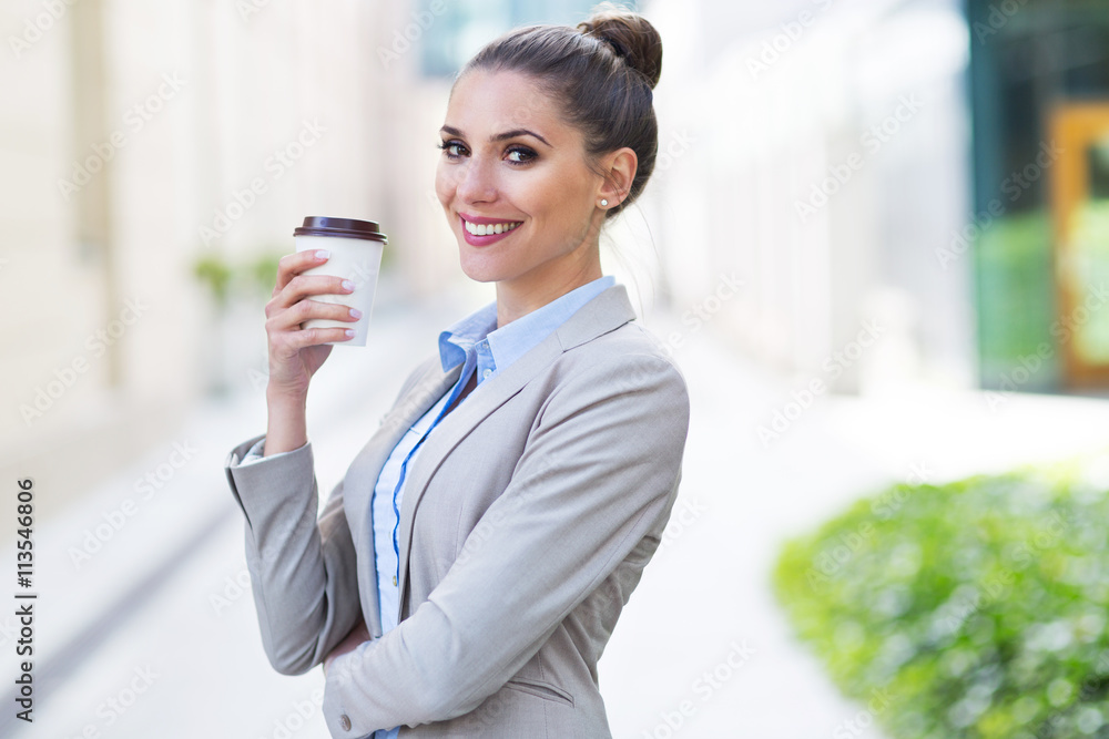 Fototapeta premium Businesswoman holding coffee outdoors 
