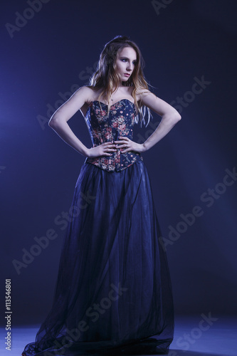 Portrait of a woman in a beautiful dress with a floral pattern in the Studio