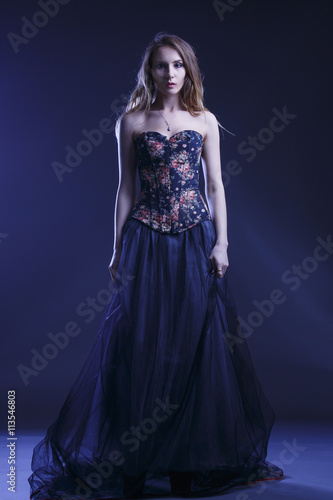 Portrait of a woman in a beautiful dress with a floral pattern in the Studio