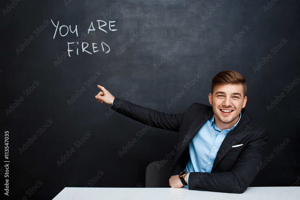image of young man over blackboard with text you are fired image of young man over blackboard with text you are fired