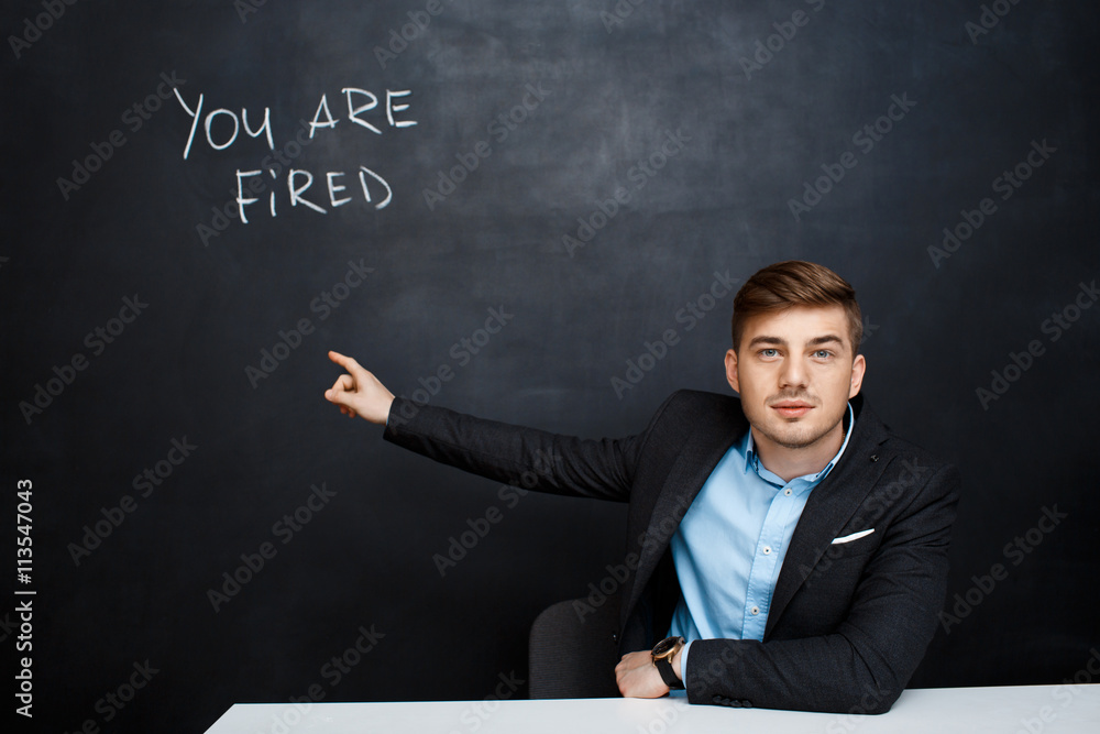 image of young man over blackboard with text you are fired image of young man over blackboard with text you are fired