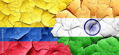 Colombia flag with India flag on a grunge cracked wall