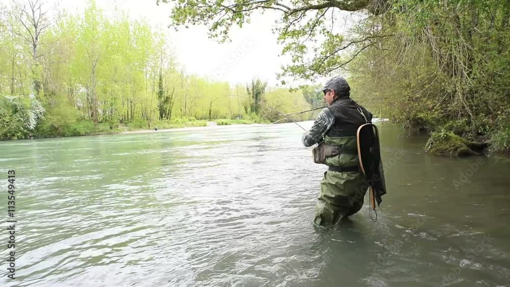 Fly-fisherman catching brown trout in river Fly-fisherman catching brown trout in river