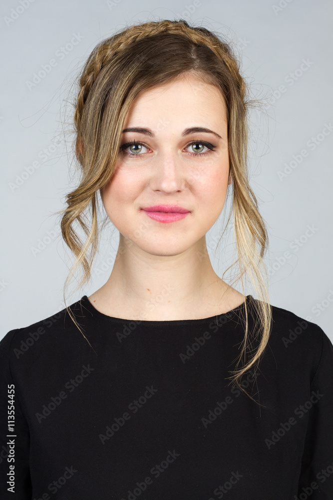 Beautiful blond girl with blue-green eyes on a white background. She wears a black t-shirt. Beautiful blond girl with blue-green eyes on a white background. She wears a black t-shirt.