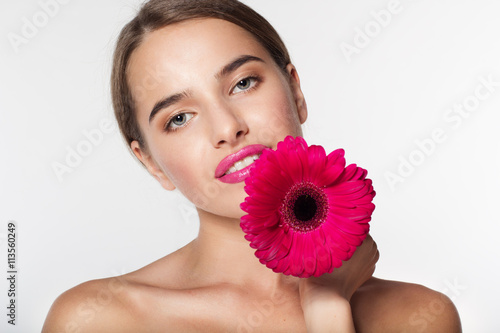 Beautiful girl with perfect skin holding gerbera flower