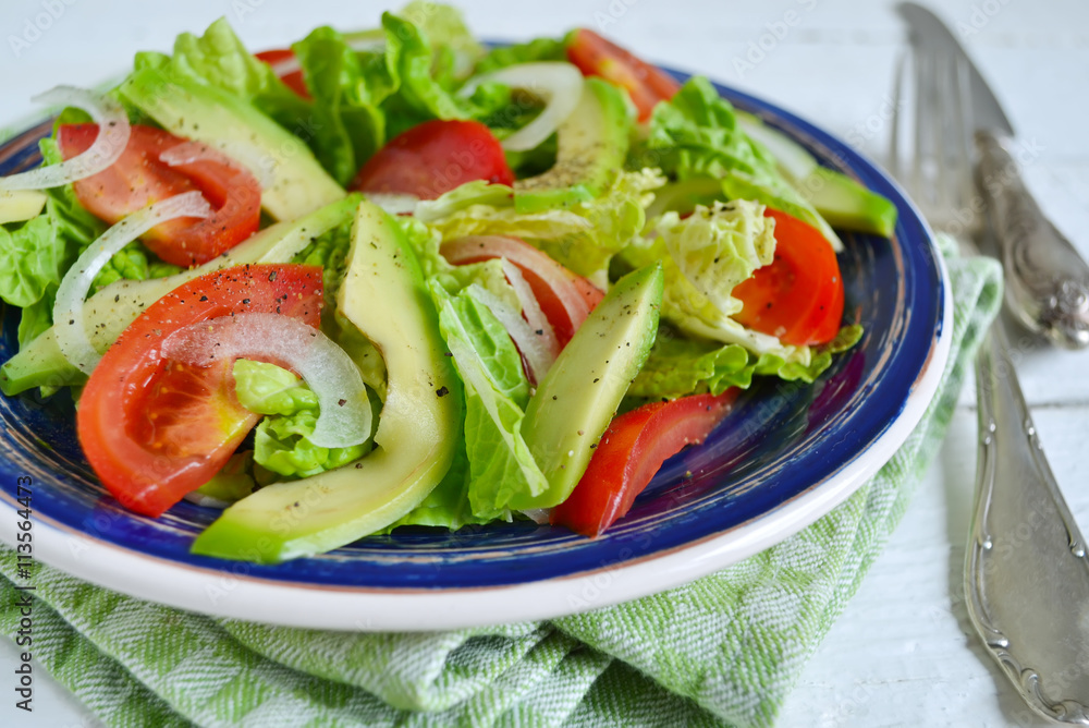 Salad with avocado, tomato, romaine lettuce and olive oil dressi Salad with avocado, tomato, romaine lettuce and olive oil dressi