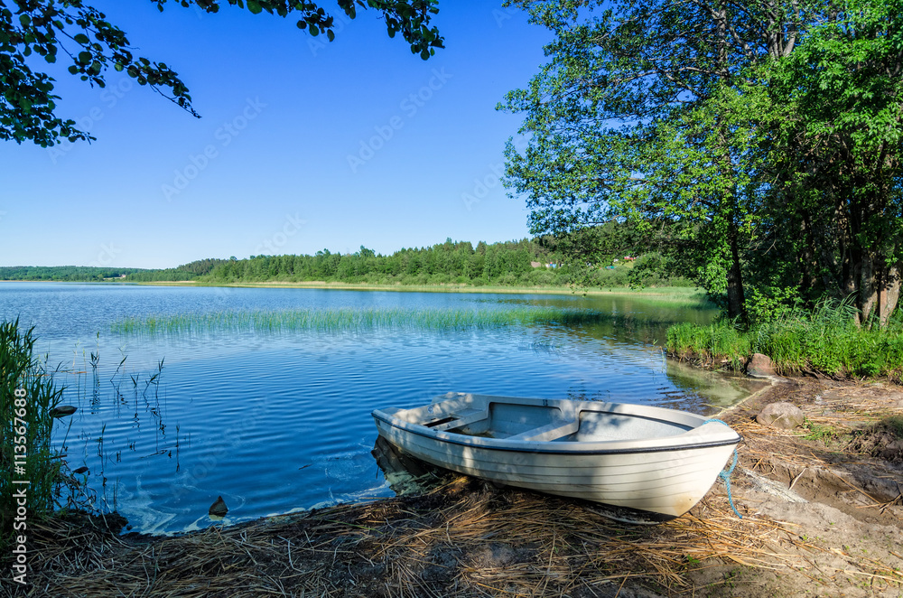 White boat on Norwegian lake coast White boat on Norwegian lake coast