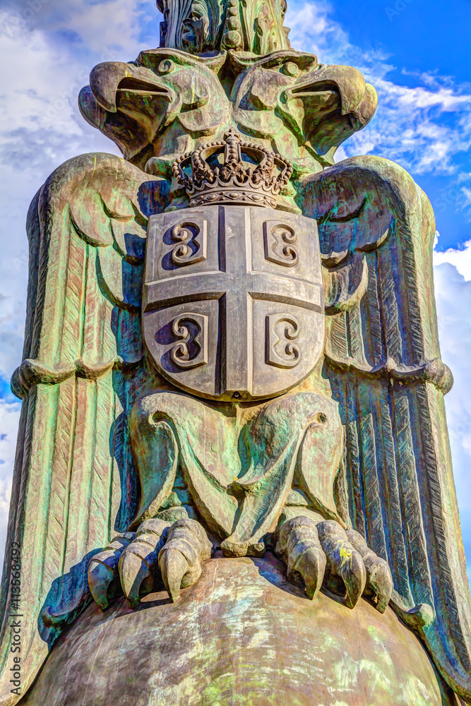 Eagles with shields and crowns at the bottom of the mast, in front of Serbian Parliament.