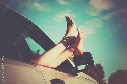 Woman legs out car window. Freedom or travelling concept