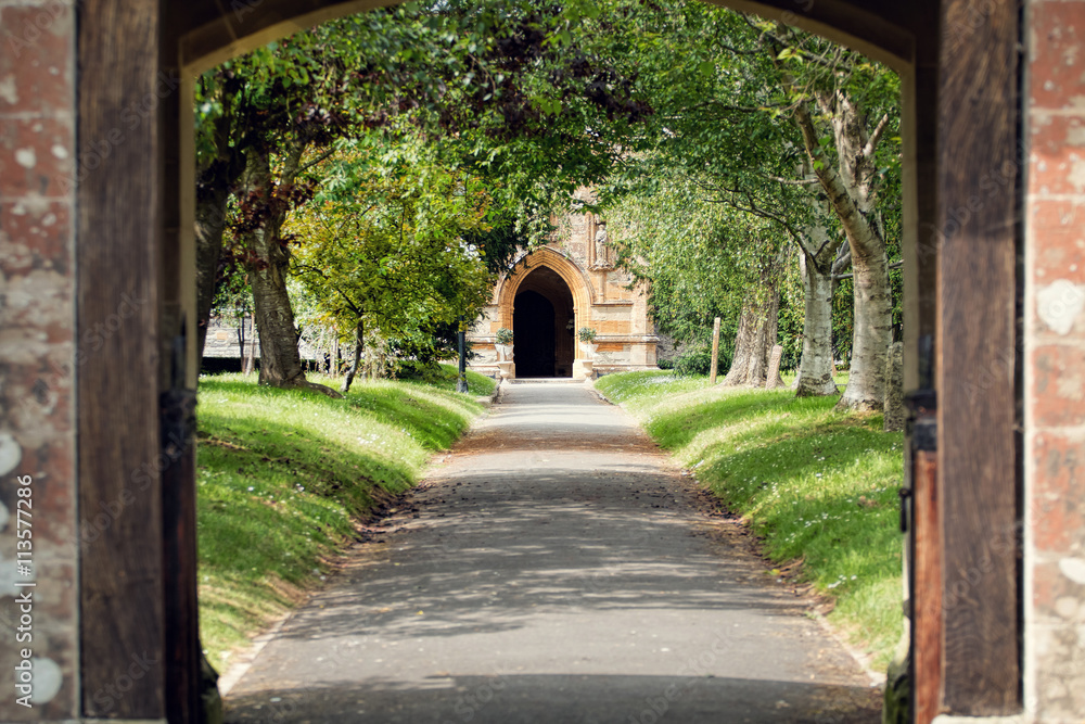 Obraz premium Church Path. Peaceful tree lined pathway through churchyard.