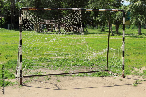 old football goal with a ripped mesh