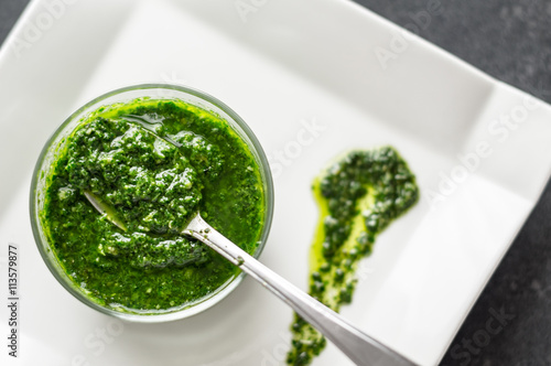 Fresh basil pesto. Fresh homemade basil pesto sauce in a glass jar. Originally from italy, pesto is commonly made with basil and used as a sauce for pasta.