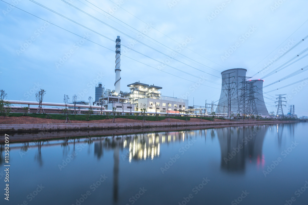 modern power station near river at twilight modern power station near river at twilight
