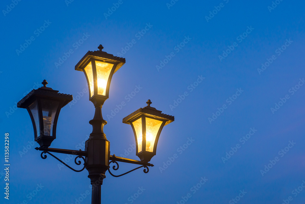 Vintage lamppost at night, isolated.