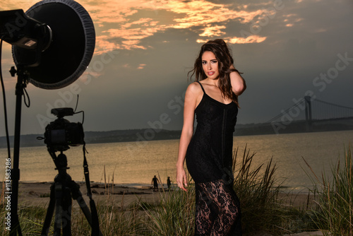 Photo shoot of  beautiful brunette model at the beach during sunset time. photo