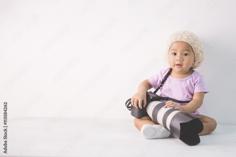 little baby girl sitting on the floor holding dslr camera little baby girl sitting on the floor holding dslr camera