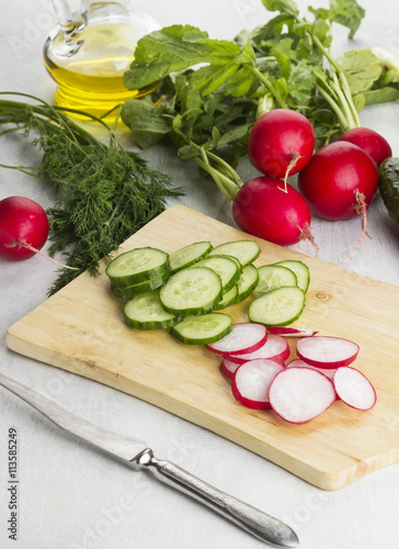 Various vegetables: garden radish, cucumbers, onions on a white