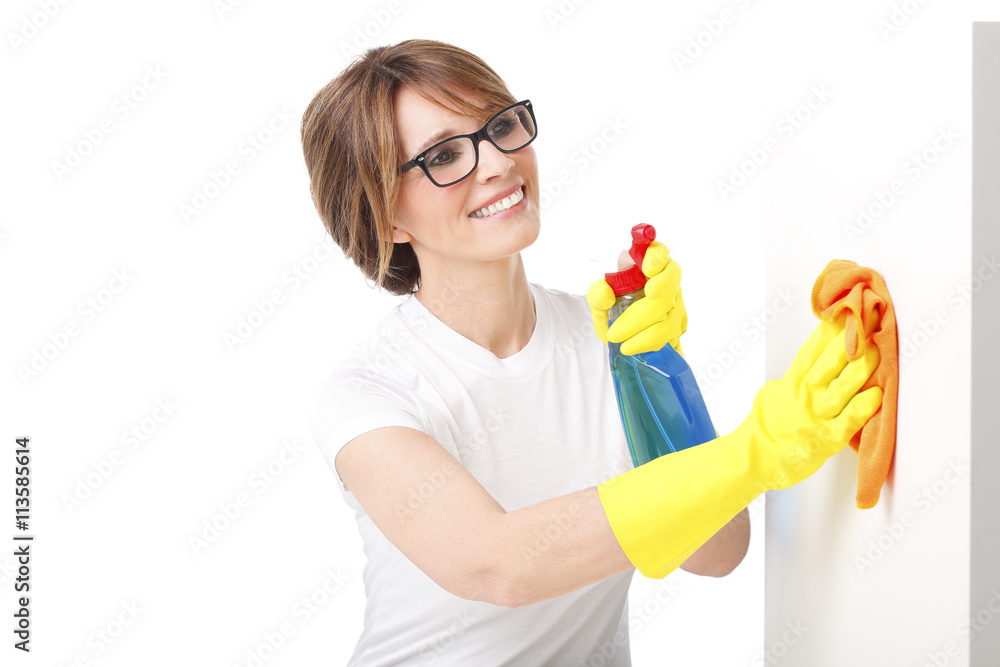Portrait of an attractive blond woman cleaning house. Smiling housekeeper cleaning surfaces Portrait of an attractive blond woman cleaning house. Smiling housekeeper cleaning surfaces