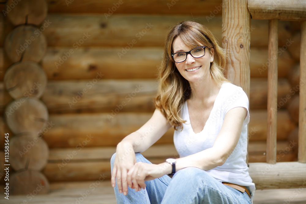 Smiling middle aged woman relaxing outside her home Smiling middle aged woman relaxing outside her home