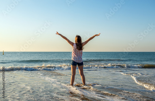 Happy young woman enjoys summer and sea
