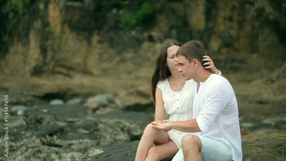 Couple sitting on the rocks at a beach. Couple sitting on the rocks at a beach.