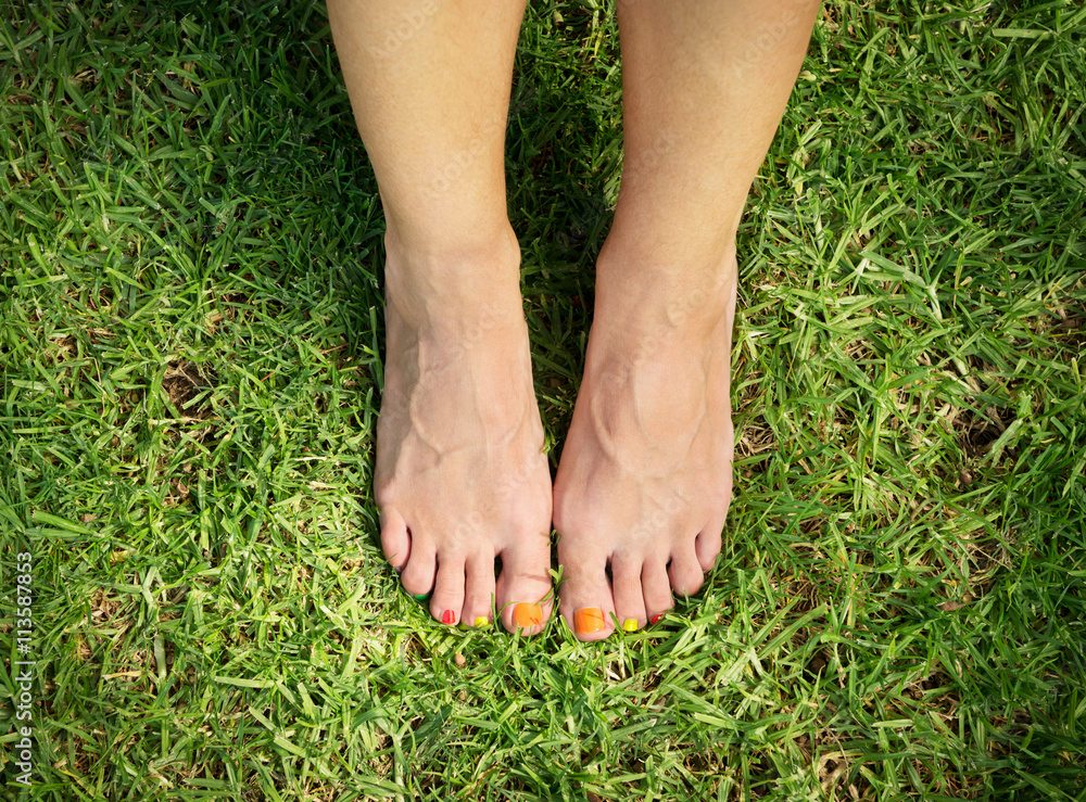 female feet on green grass