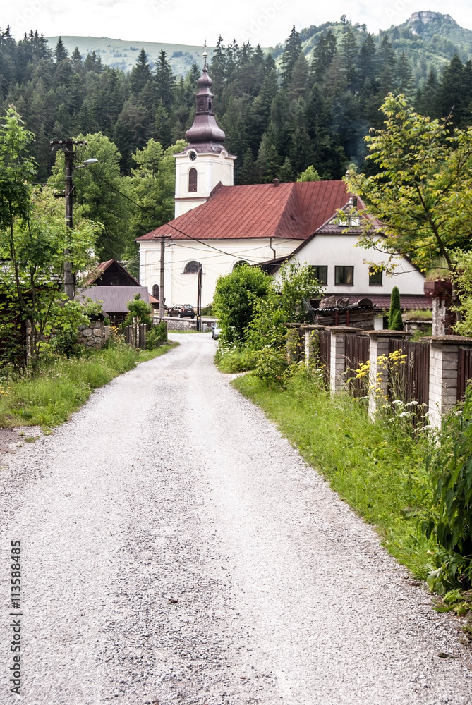church in Stare Hory with road and Velka Fatra mountains on the background in Slovakia