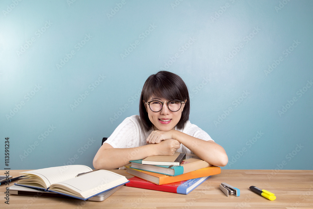 Portrait of clever  asian student with open book reading it