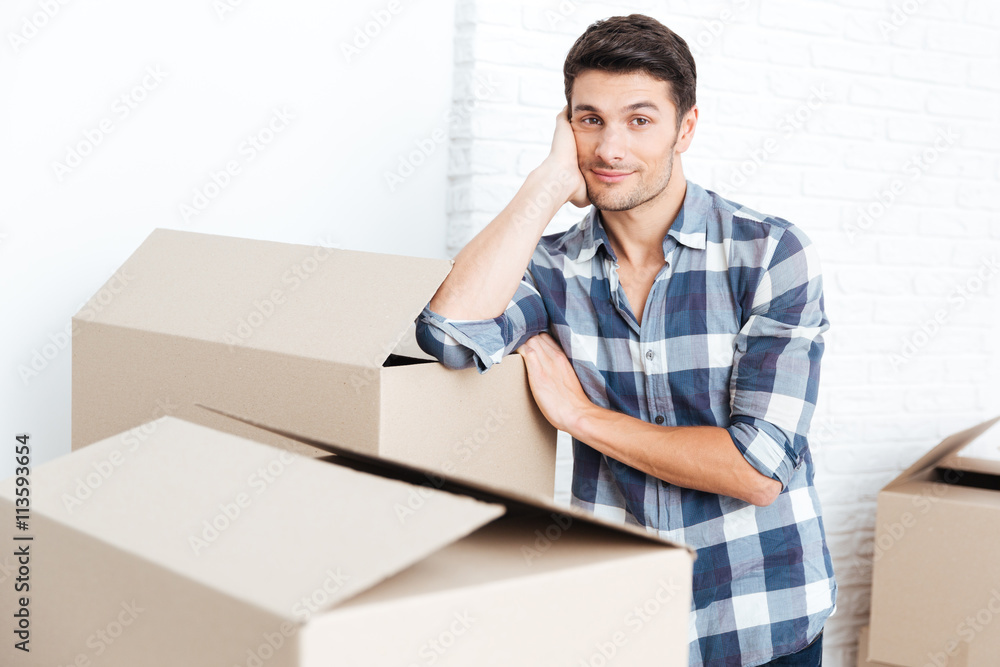 Happy man moving in and carrying carton boxes Happy man moving in and carrying carton boxes