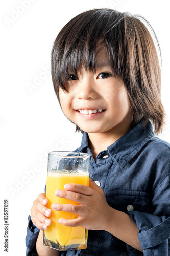 Asian kid holding glass with orange juice.