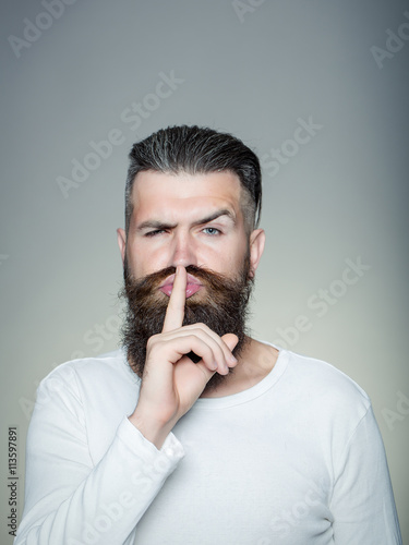 Bearded man with hush gesture