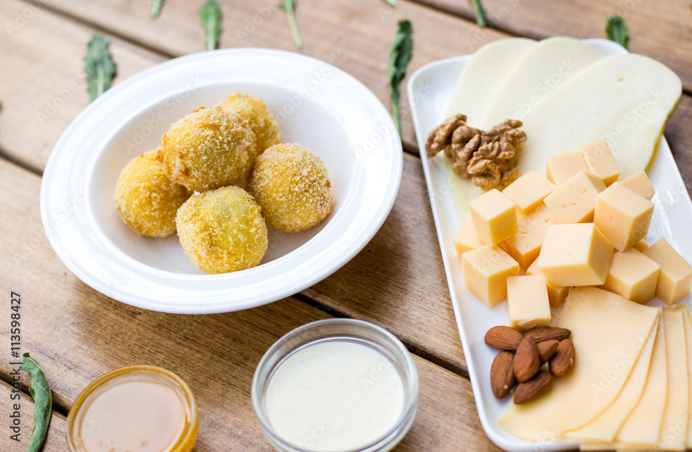 Appetizer of cheese. Different types of cheese, sauce, nuts