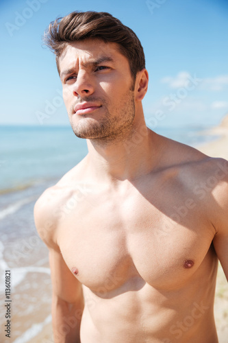 Attractive shirtless young man on the beach
